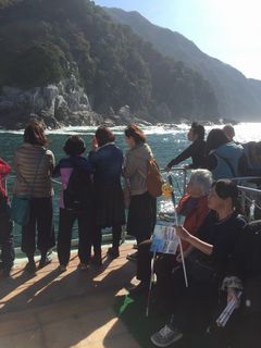 甲板で部員が並んで島の景色を眺めているとこと