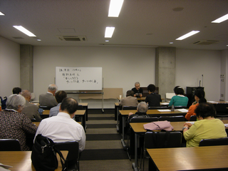講演会の会場(会議室)全体を後ろから全体を写した写真。
