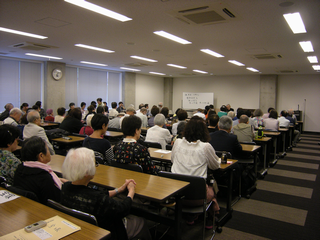 参加者が話に聞き入っている様子が写っている写真。